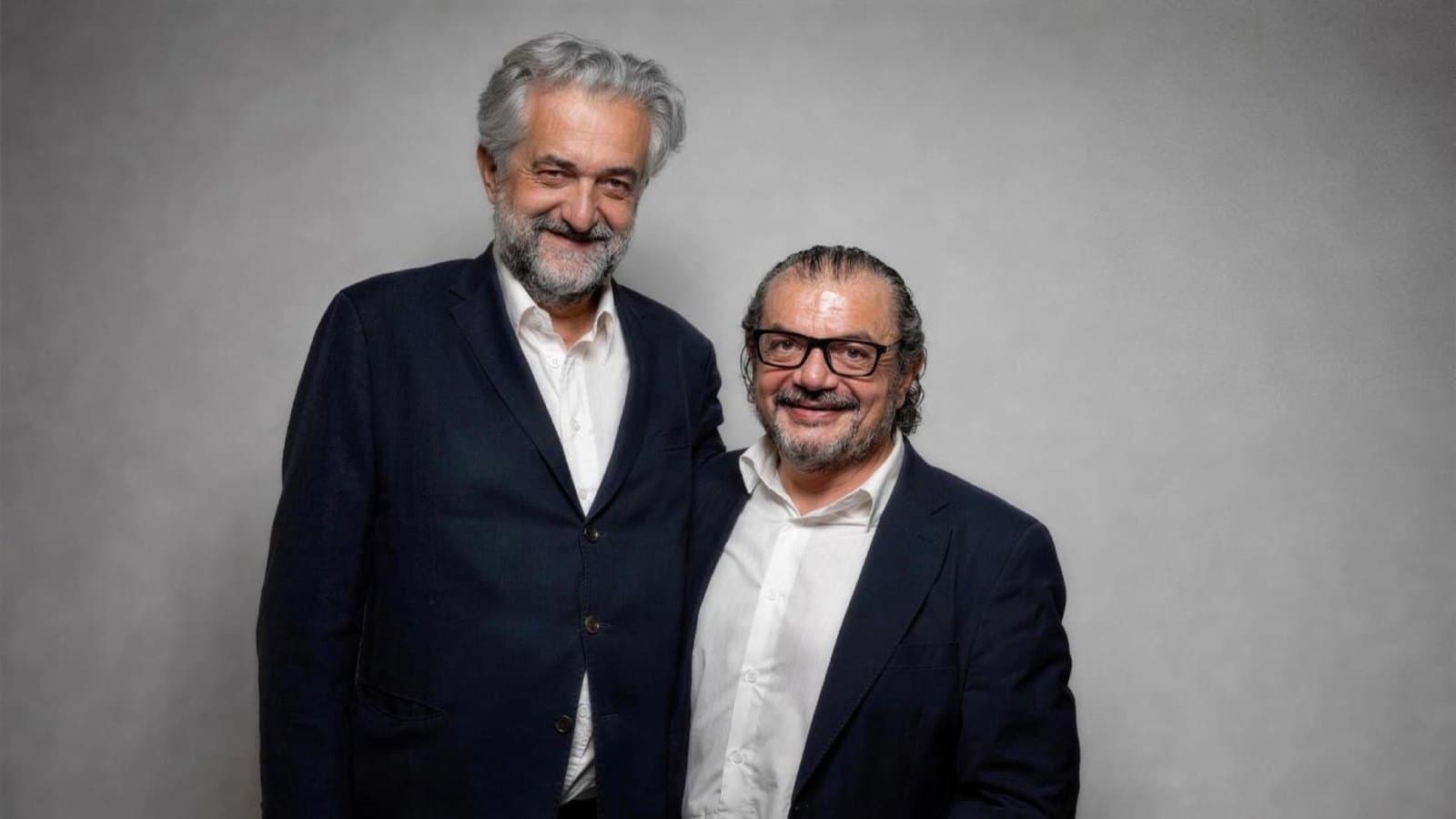 Luca Alinovi and Fabrizio Cardillo, the founders of Aflabox, standing side by side in dark jackets against a grey studio background.