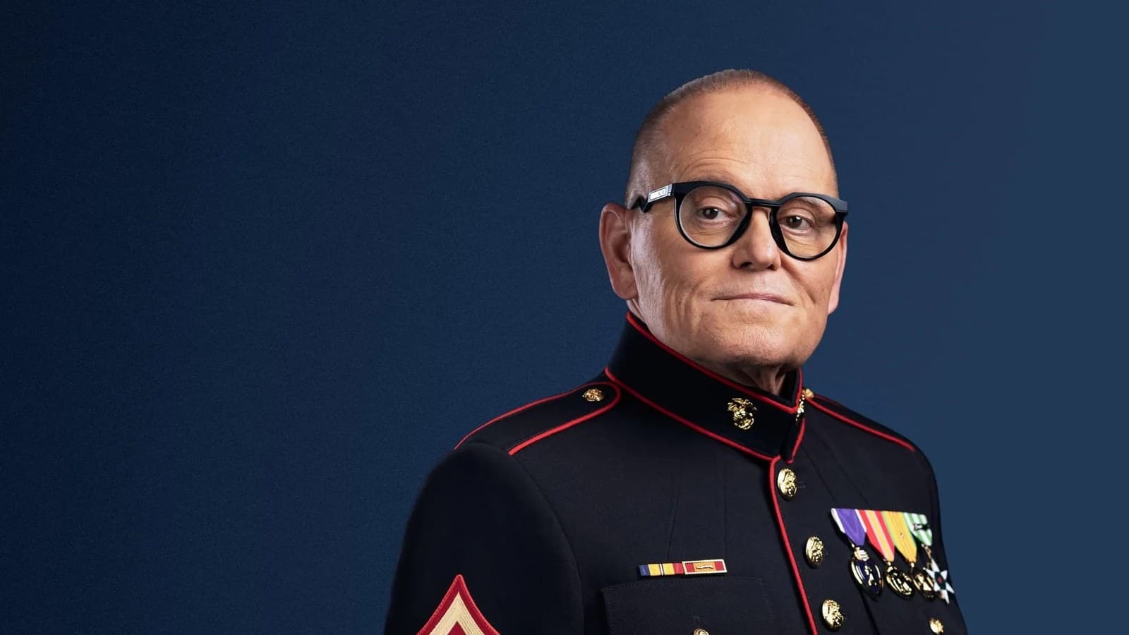 Bob Parsons, con occhiali e l'uniforme da parata dei Marines con le medaglie, guarda in camera su sfondo blu scuro.