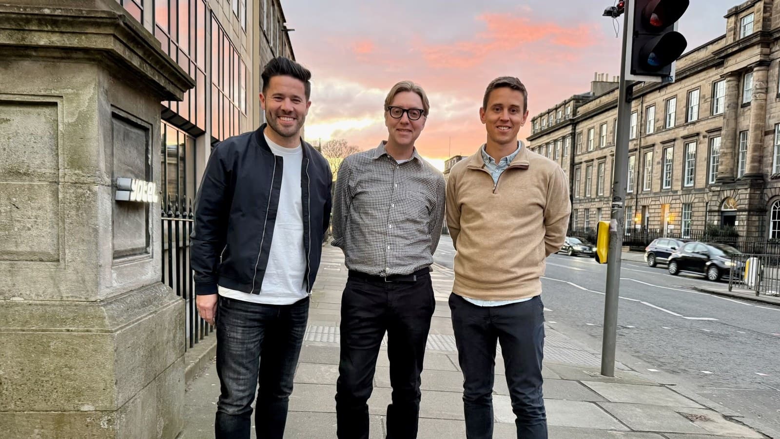 Tim Shey con i cofondatori Ian Shepherd e Owen Maher su una strada di Edimburgo al tramonto.