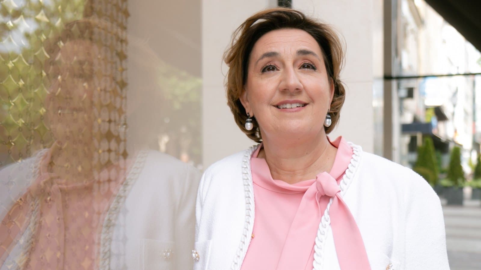 Marie-Christine Mariani, founder of MCM Steel, in a white jacket and pink blouse, photographed beside a shop window. Foto d'archivio.
