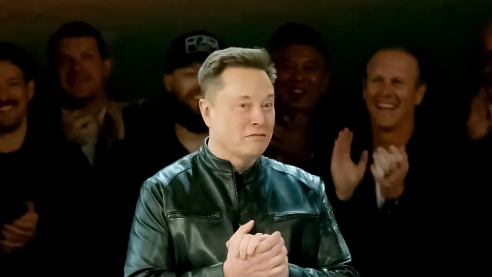 Elon Musk standing with his hands clasped in front of an applauding crowd at a company event. Foto d'archivio.