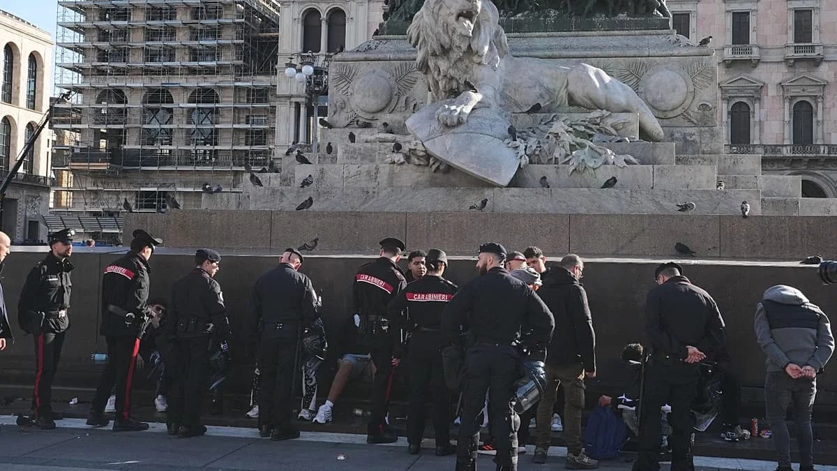 Carabinieri in servizio lungo un muretto vicino a un monumento in una piazza di Milano dopo gli scontri del fine settimana.